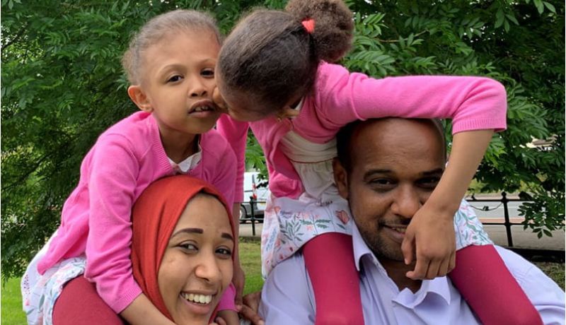 Rital and Ritag ride on their parents' shoulders.