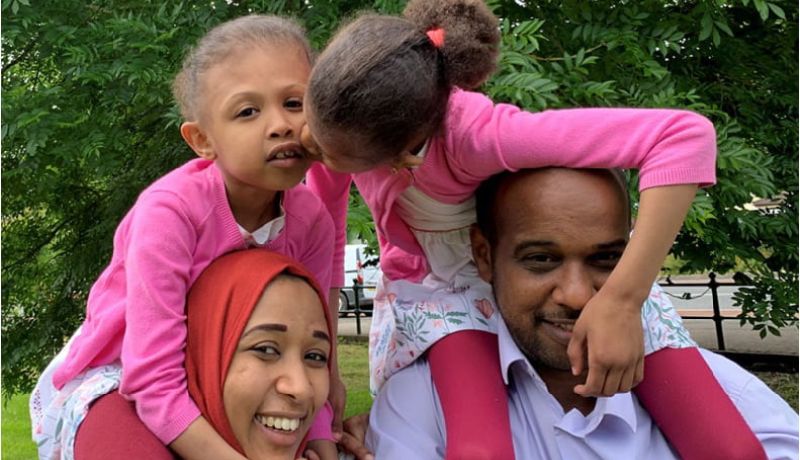 Rital and Ritag ride on their parents' shoulders.